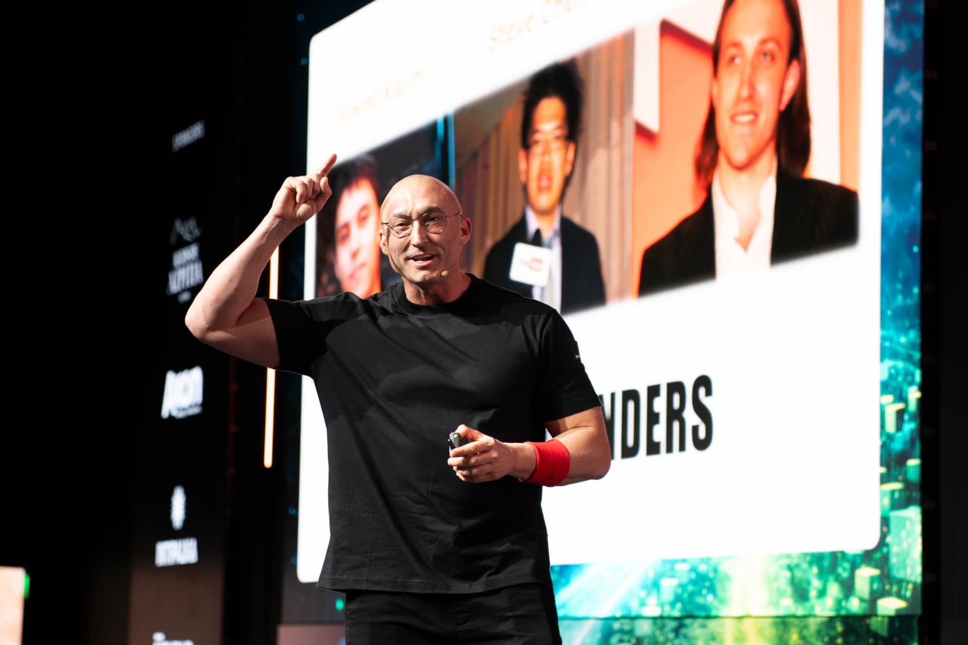 JJ Delgado en un escenario de un evento global de liderazgo, dirigiéndose al público.
